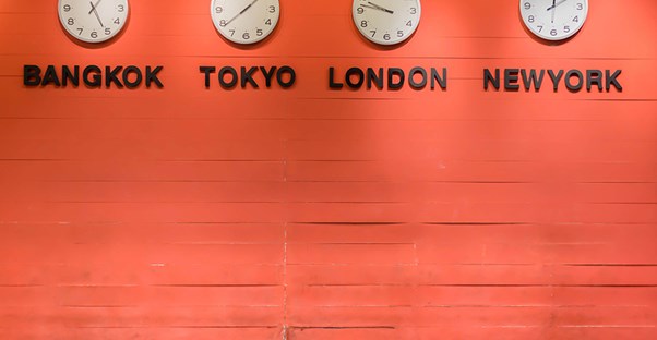 Four time zone clocks on a wall