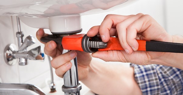 Plumber tightens with a tool