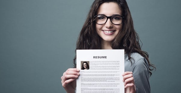 A young professional holds up her resume proudly