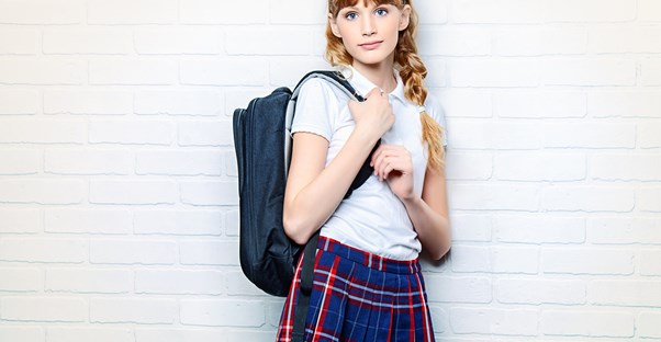 A young girl wears a uniform to school