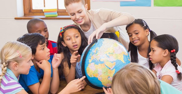 A teacher shows her students a globe