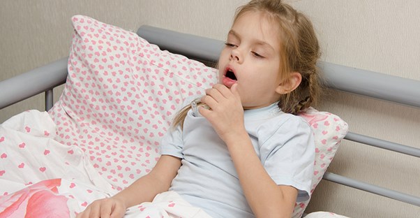 child coughing in her bed