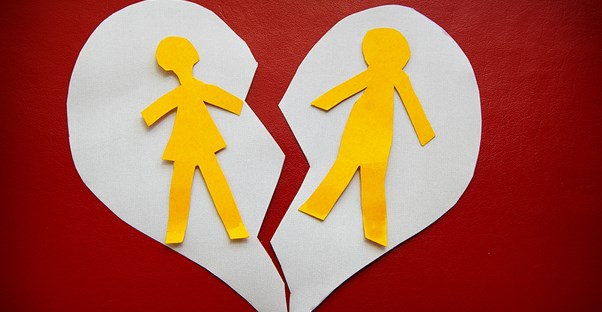 a paper heart with outlines of a man and woman being separated down the middle by a tear
