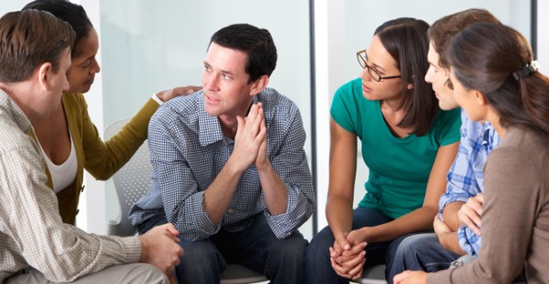 a divorce support group comforts a man who is sharing an experience