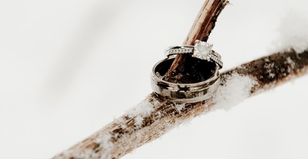 Wedding rings on a snow covered stick to symbolize a winter wedding