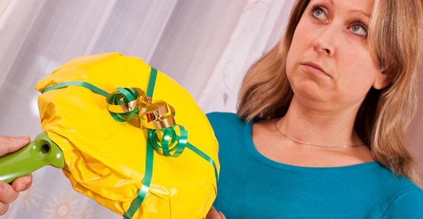 A woman unhappily receiving a skillet from her husband for Christmas.
