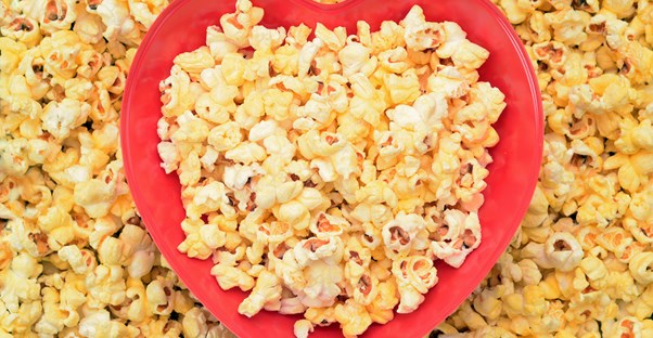 A heart-shaped bowl filled with popcorn to eat on Valentine's Day