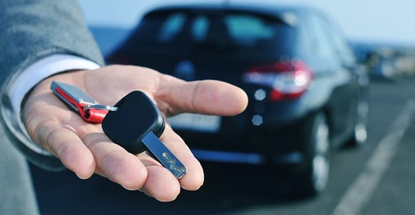 person holding keys to new car
