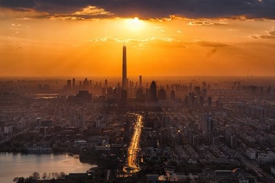 the tall buildings of a city in front sunset