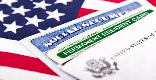 Social Security Card and Permanent Resident Card laying on an American flag