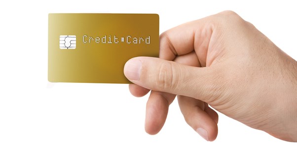 a hand holding a gold hotel rewards credit card