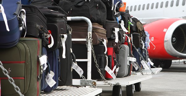 a pile of luggage waits to be loaded into the cargo hold of an airplane