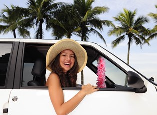 a young woman enjoys the road in her newly rented car