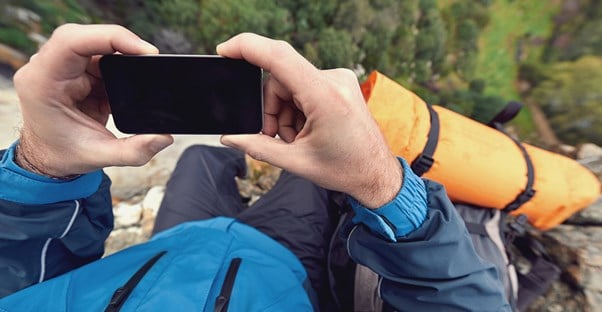 a hiker uses an app to determine a location on a map