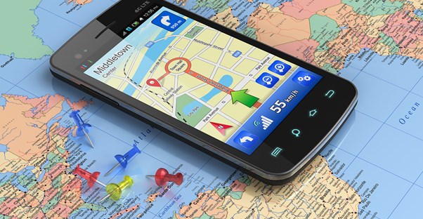 a GPS app sits open on a cell phone which lies on top of a map