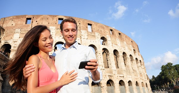 a couple in front of the colosseum uses their travel app