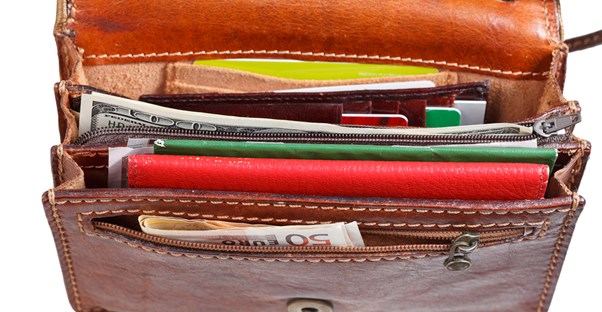 a thick travel wallet is packed full of bills, cards, and important documents