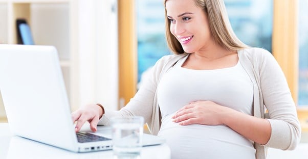 Pregnant woman looking at laptop screen