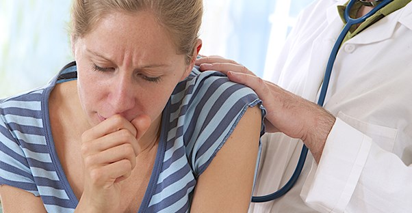 woman at the doctor being examined for her cough
