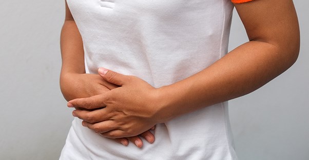 woman holding stomach because something she ate is causing diarrhea