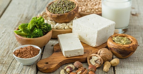 Blocks of tofu, raw broccoli, legumes, and beans. Health benefits of eating vegan.