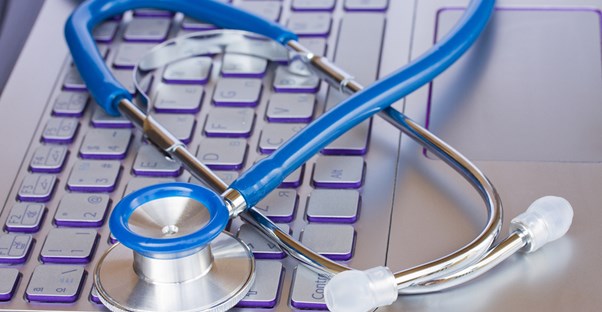 a stethoscope and a keyboard that represent electronic health records