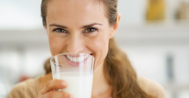 a woman drinking milk to fight osteoporosis