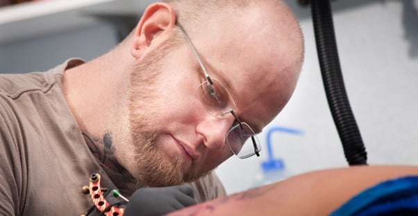 a man giving a woman a horrible tattoo