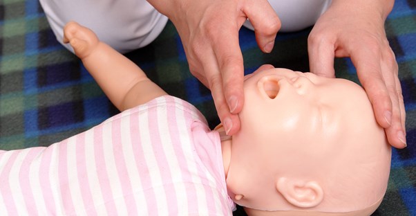 a man practicing CPR on a baby