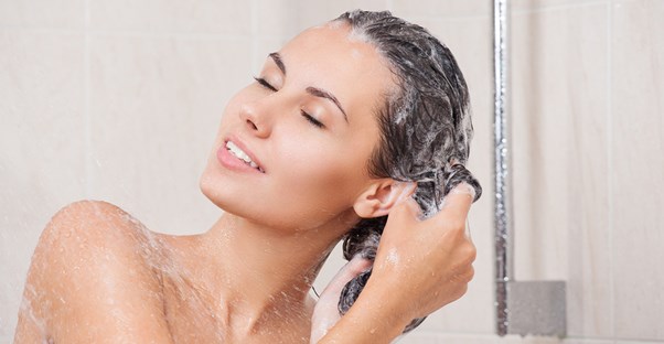 a woman fixing her oily hair with shampoo
