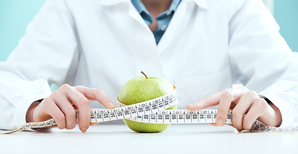 a nutritionist measuring an apple